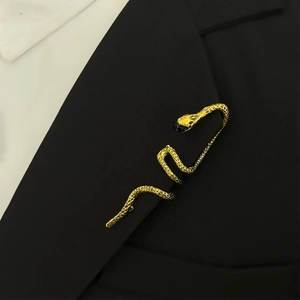 Detail of vintage gold snake brooch with scale texture on a black suit lapel