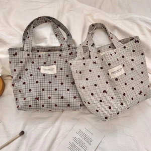 Détail de sacs à lunch en toile quadrillée avec pois rouges et motifs de nœuds papillon