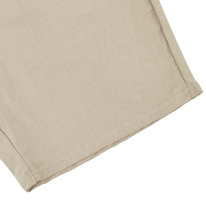 Close-up of beige linen shorts with durable double-stitched hem and textured fabric