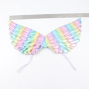 Detailed view of iridescent angel wings props for kids with measurement ruler on white background
