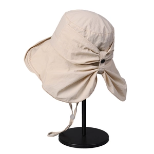 Beige wide brim sun hat with neck protection and bow detail on a white background
