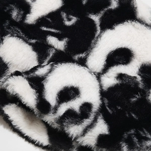 Gros plan sur la texture en fausse fourrure douce à motif vache noir et blanc du chapeau d'hiver