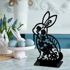 Detailed view of hollow black wooden bunny silhouette with floral patterns on desk