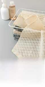 Detail view of woven exfoliating bath towels in beige and green for deep cleansing