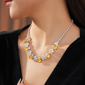 Detailed view of flower necklace featuring yellow and white cubic zirconia stones on model