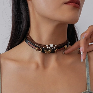 Close-up of vintage leather choker with butterfly and heart charms on model