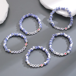 Dettaglio di cinque braccialetti in ceramica blu e bianca con scritte familiari e cuori