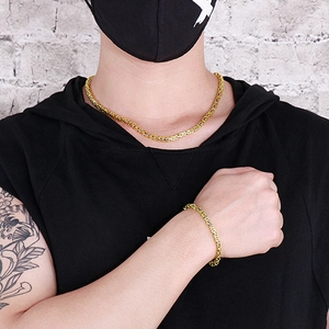 Close-up of dual-tone silver and gold Byzantine chain necklace and bracelet set