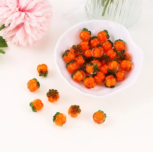 Detailed view of handmade pumpkin-shaped orange glass beads for DIY jewelry making