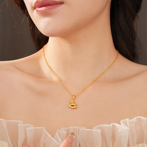 Detail of a gold-plated horse pendant necklace with sparkling stones worn by a model