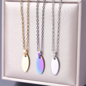 Macro detail of oval pendant necklaces in gold, silver, and rainbow plated stainless steel