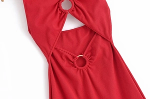 Dettaglio macro dell'abito in maglia a coste rosso con cut-out e anello in metallo dorato