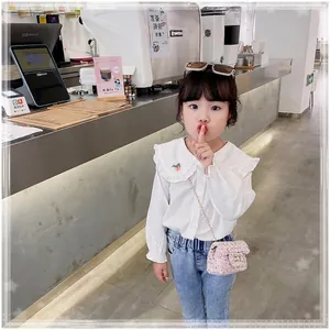 Rosa Tweed-Mini-Kettentasche für Mädchen kombiniert mit weißem Hemd und blauer Jeans