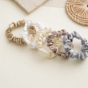 Set of five satin scrunchies in Morandi colors displayed on a minimalist background