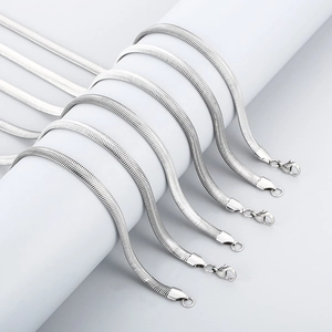 Detailed view of silver flat snake bone chains with lobster clasps on jewelry props