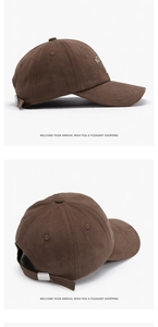 Detail of dark brown cotton baseball cap showing white embroidery and metal adjustment buckle