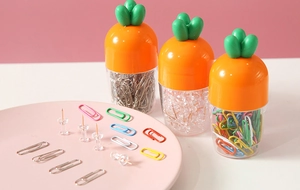 Detailed view of carrot-shaped office organizers with metal paperclips and clear pushpins