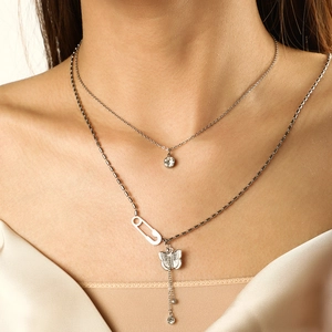 Detail of silver layered butterfly necklace with safety pin clasp and zircon pendant