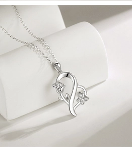 Close-up of S925 silver heart necklace featuring rose and butterfly details with crystals