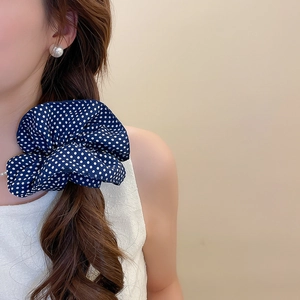 Close-up of navy blue polka dot fabric scrunchie on a ponytail for hair styling