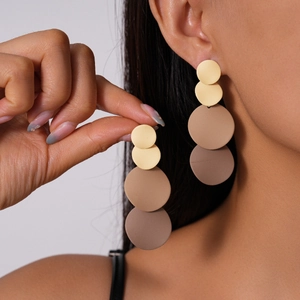 Detail of matte gradient round disc drop earrings shown on model with neutral studio lighting