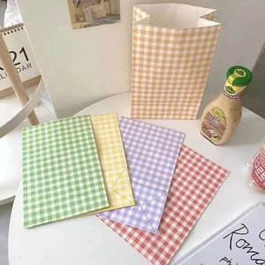 Colorful checkered paper gift bags in orange, green, and yellow for party favors