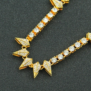 Detail of gold Cuban chain necklace with spiked cone pendants and pave-set zircons