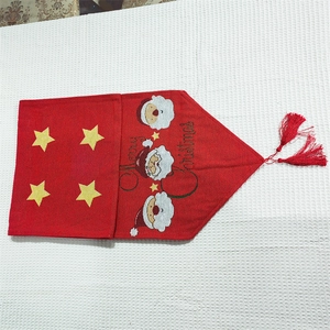 Red Christmas table runner with Santa Claus embroidery and festive tassels decoration