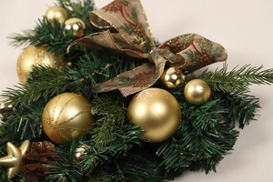 Detail von goldener Weihnachtsdekoration, Zapfen und Juteband auf grünem PVC-Zweig