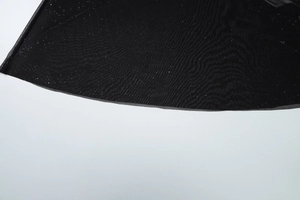 Gros plan sur le tissu en maille noire avec détails scintillants et drapé élégant