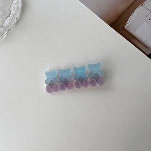 Macro shot of bear-shaped hair clips with a realistic frosted purple gradient finish
