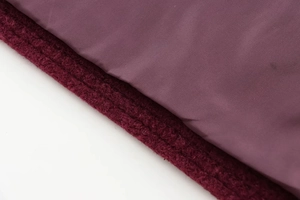 Gros plan sur le tissu en tweed bordeaux montrant la texture et la doublure lisse