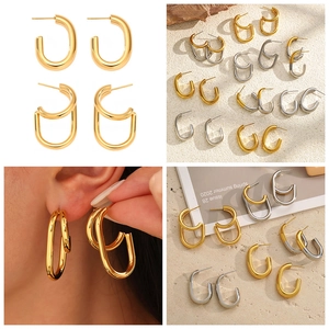 Detailed close-up of double-layered C-shape earrings in gold and silver finishes