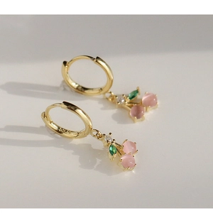 Detailed macro view of S925 silver cherry earrings with pink beads and green gemstone