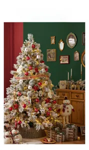 Close-up of snow-flocked Christmas tree with red baubles and brown wicker tree collar