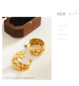Detailed macro view of 18K gold plated hoop earrings with embossed heart texture