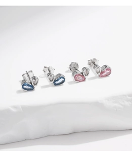 Detailed macro view of S925 silver heart earrings with blue and pink cubic zirconia