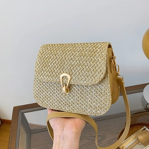 Fashionable woven crossbody straw bag with gold hardware and khaki leather trim