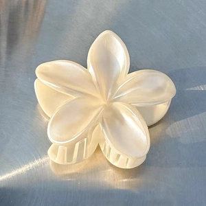 Close-up of elegant pearl white lily hair claw clip with a glossy floral finish
