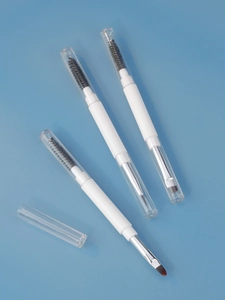 Dual-ended makeup brushes with spiral brow brush and soft concealer bristles on blue background