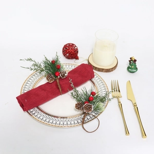Détail du rond de serviette de Noël avec aiguilles de pin et pommes sur table de fête