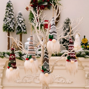 Detail of five hanging Christmas gnomes with knitted hats and faux fur beards on white branches