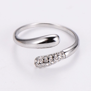 Macro detail of silver-tone embrace ring showing the polished metal and micro-inlaid zircons