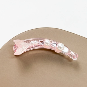 Detail of pink fish tail banana hair clip with rhinestones and faux pearls