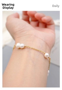 Detailed close-up of a minimalist gold wire pearl bracelet on a woman wrist