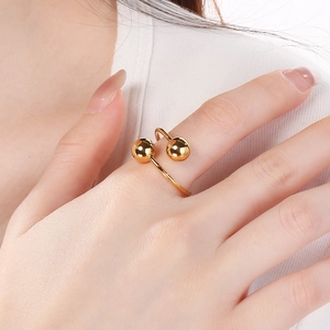 Detail of 18k gold plated stainless steel open ring with double ball design on finger