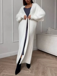 Dettaglio del lungo cardigan bianco in maglia con morbida trama in pelliccia sintetica