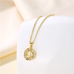 Macro detail of 18K gold stainless steel letter J pendant with zircon stones