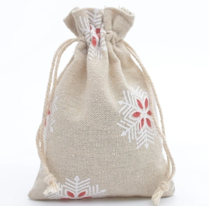 Detailed macro view of beige linen drawstring pouch with red and white snowflake prints