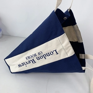 Dettaglio della borsa in tela con cuciture a contrasto e fibbia magnetica in metallo